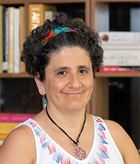 Headshot of Dr. Ana Maria del Rio-Gonzalez with books in the background