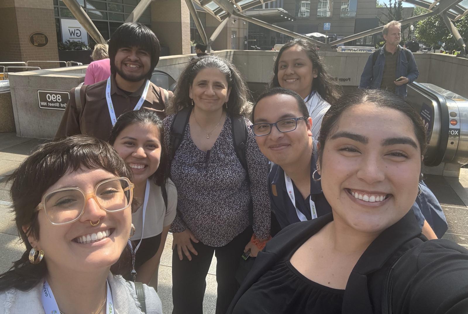 group of 6 students smiling, with one older woman who is also smiling