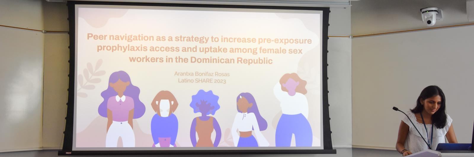 Girl next to a Slide show presentation that says "Peer Navigation as a strategy to increase pre-exposure prophylaxis access and uptake among female sex workers in the Dominican Republic" 
